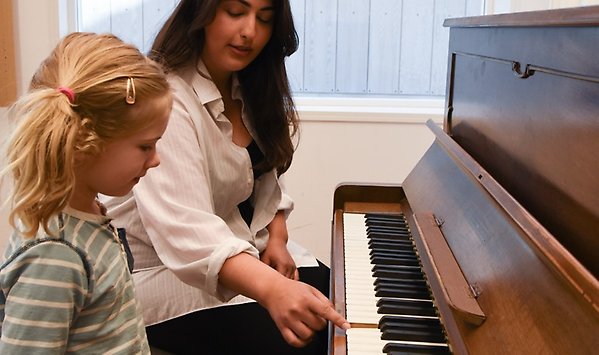En lärare undervisar ett barn i piano